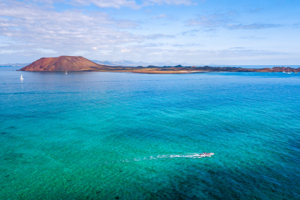 Ocean in the foreground with a rocky outcrop in the background