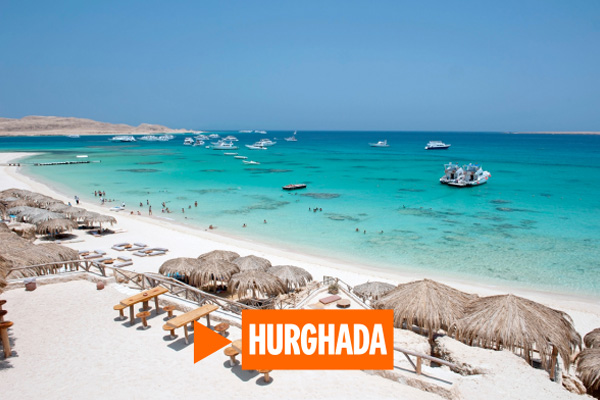 Beach in Hurghada with straw parasols running into blue waters