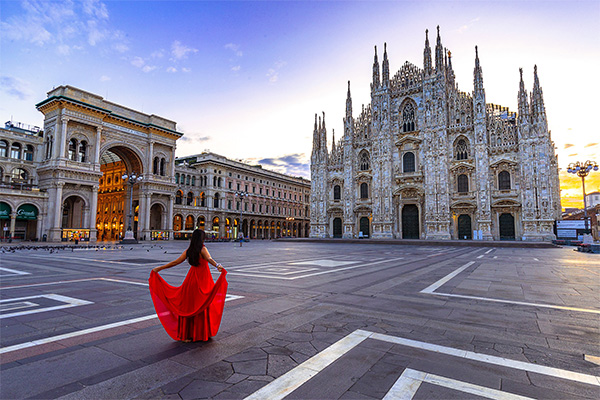 Woman wearing a red dress standing in Milan's almost-empty Duomo Square