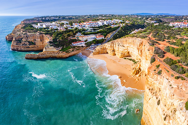 Rocky cliffs with small, secluded beach and blue waters in the Algarve