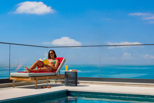 Woman sunbathing on a sun lounger by a pool