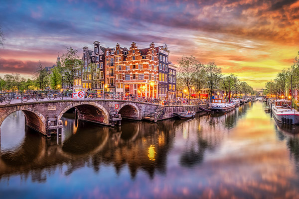 A bridge, some buildings and a canal in Amsterdam at sunset
