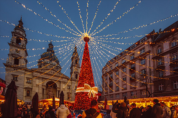 Red tree in the middle of a square with Christmas markets in it in Budapest