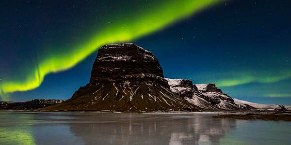A mountain in Iceland underneath the Northern Lights