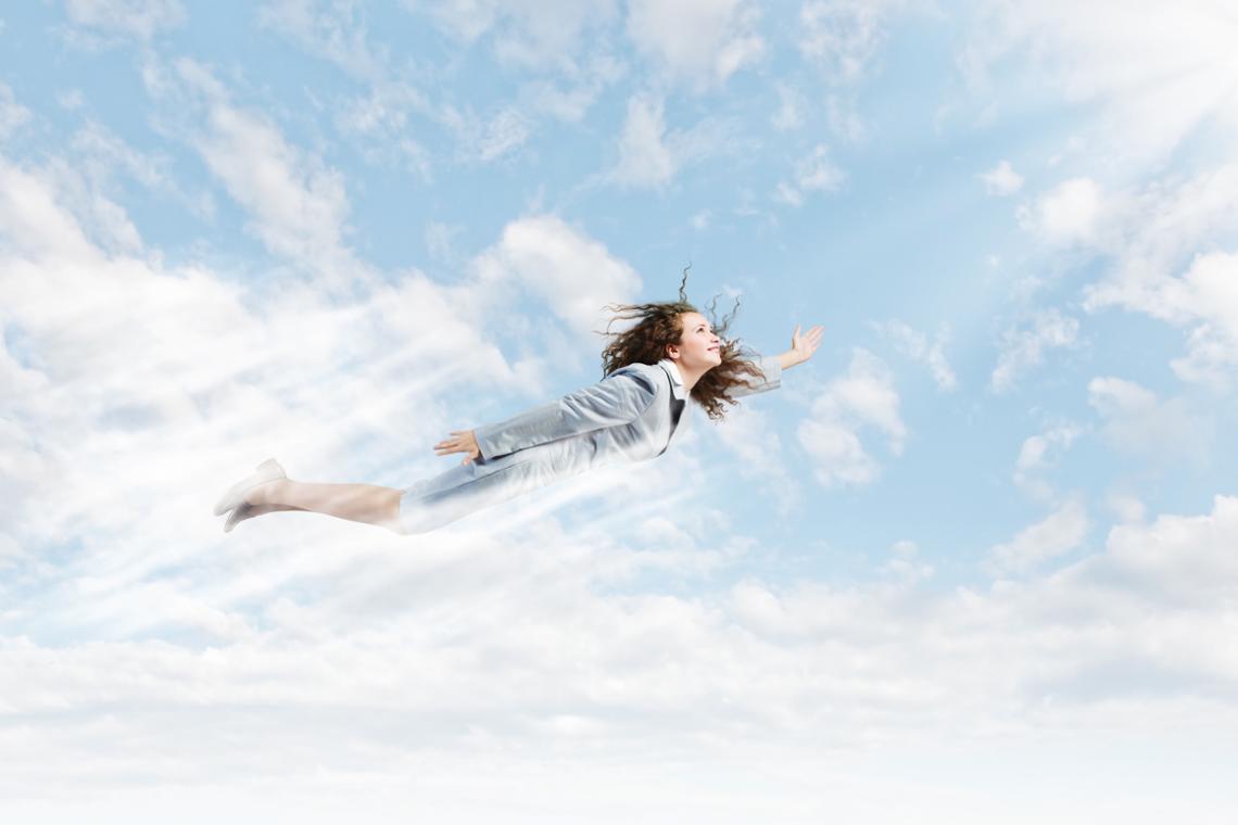 Een vrouw vliegt door de wolken