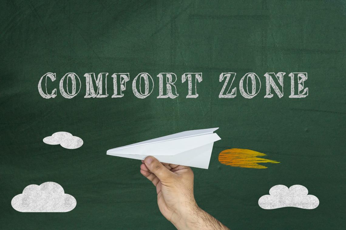 Onder de tekst Comfort Zone is een hand met een vliegtuigje te zien met een raketvlam erbij