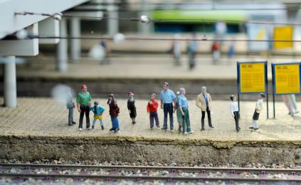 Model van een station met allemaal wachtende mensen op de perrons.