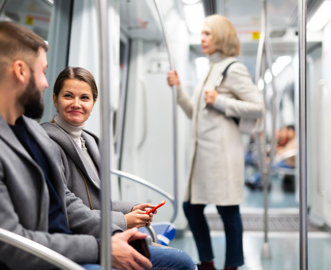 Foto van 2 personen in een trein die oogcontact maken