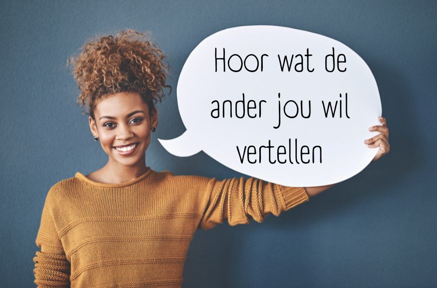 Een vrouw houdt een bord vast met de tekst Hoor wat de ander jou wil vertellen