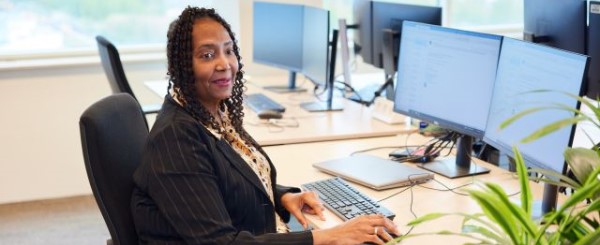 Een vrouw zit achter een bureau in een kantoortuin