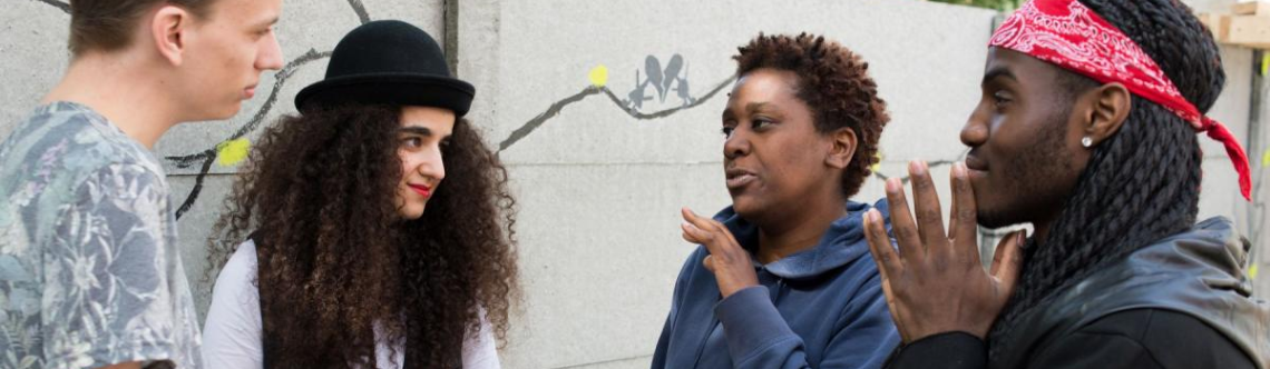 Drie mensen zitten om een vergadertafel.