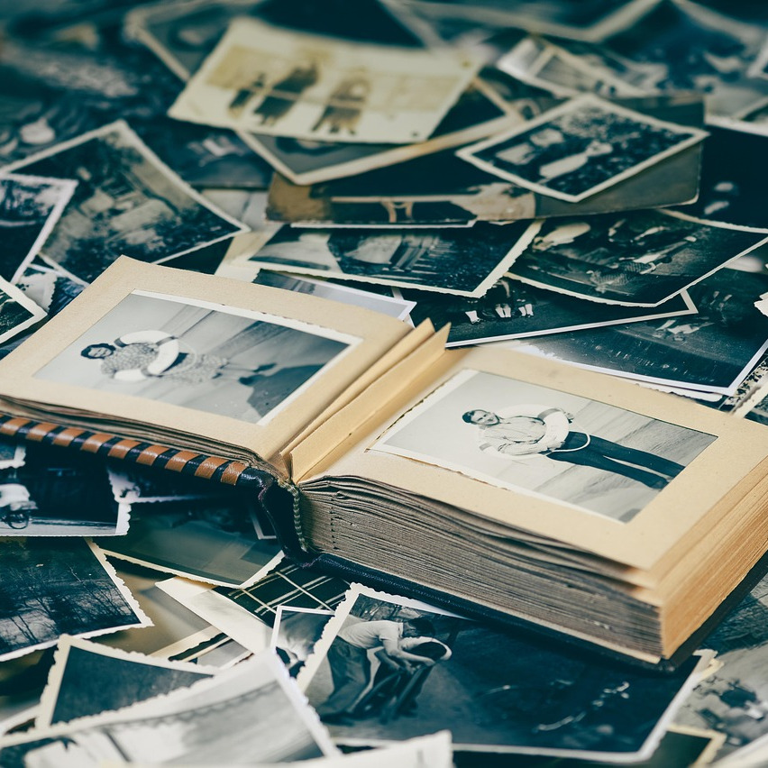 Er liggen allemaal polaroid foto's op elkaar met daar bovenop een foto-album