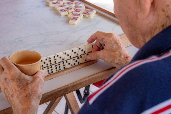 Oudere man die domino aan het spelen is