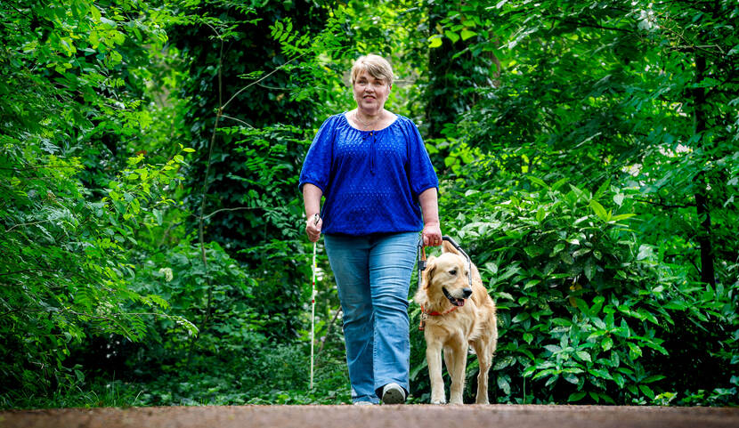 Ellen Zieleman loopt met haar assistentiehond in het bos