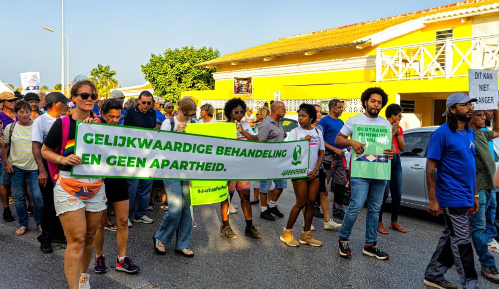 Demonstratie op Bonaire en een banner met de tekst 'gelijkwaardige behandeling en geen apartheid' 