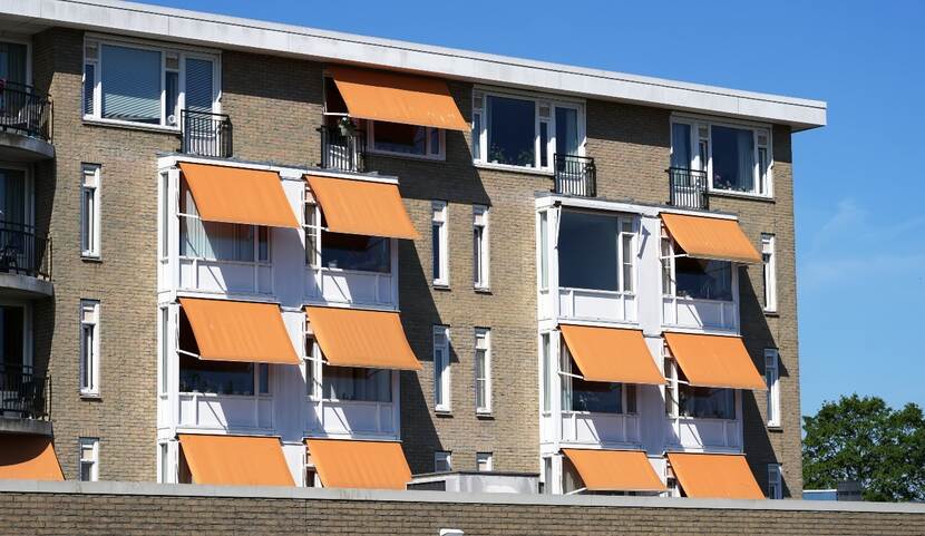 Willekeurig appartementencomplex met oranje zonwering