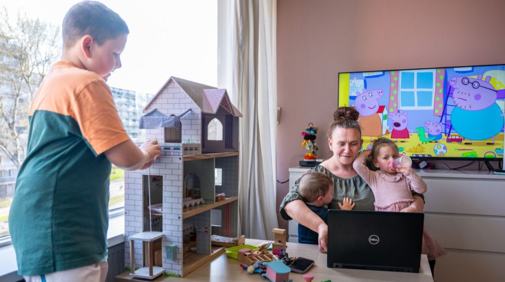 Vrouw werkt vanuit huis met haar kinderen op schoot