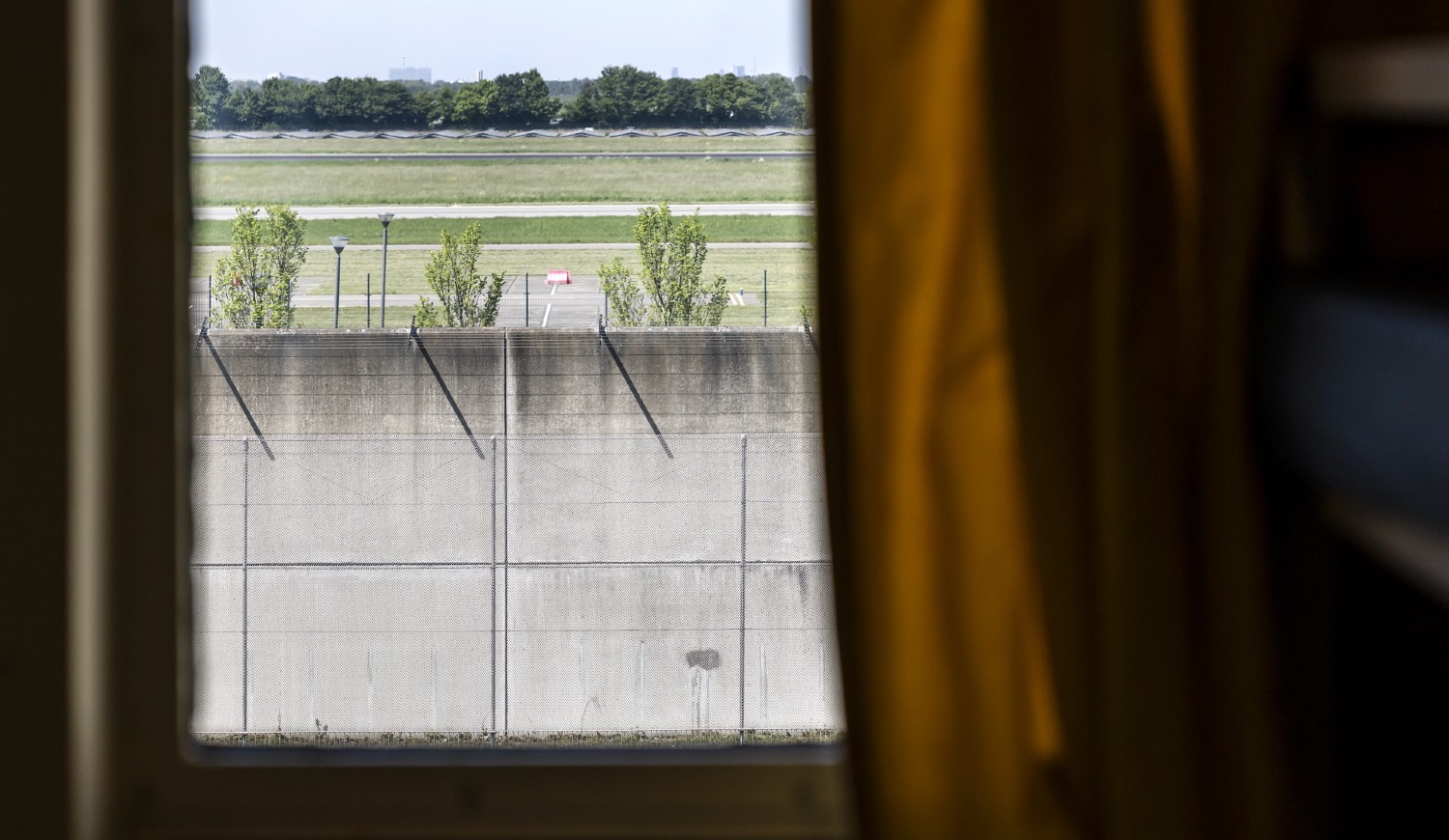Foto vanuit een raam in een gevangenis naar buiten. 