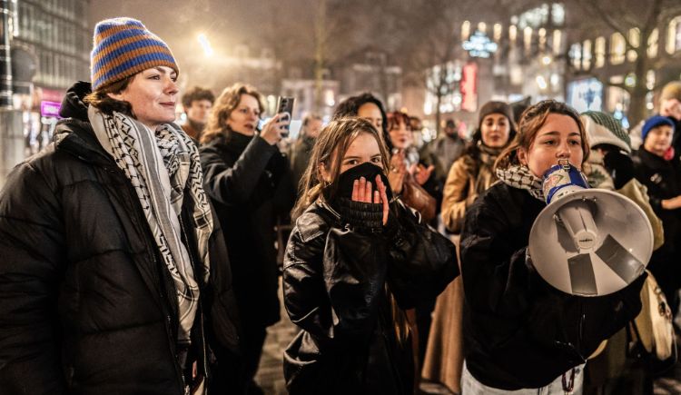 Op deze foto zijn mensen te zien die op straat demonstreren