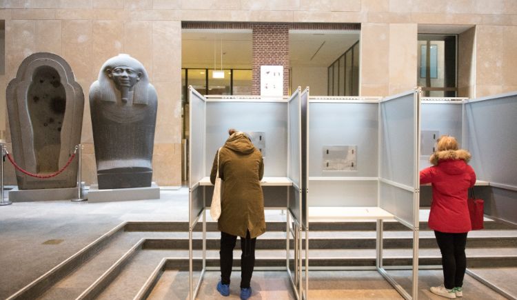 Twee mensen die stemmen in een stemhokje