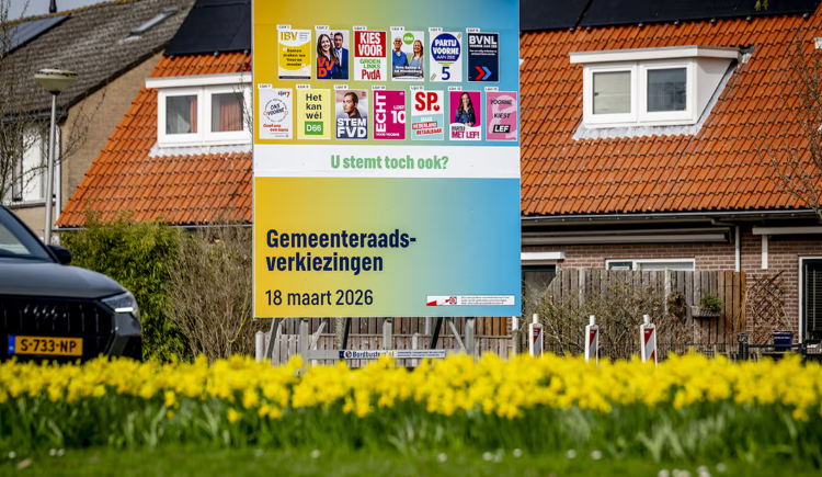 Bord met posters van politieke partijen voor de gemeenteraadsverkiezingen