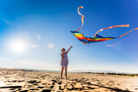 Meisje met grote vlieger op het strand