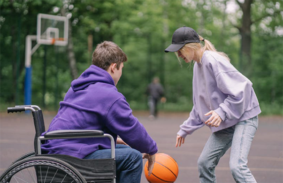 Foto gehandicapte jongen en vrouw spelen basketbal