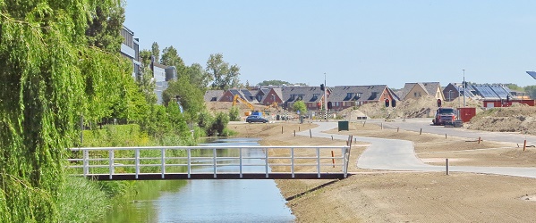 Foto van water, een brug en een nieuw geasfalteerd wandel en fietspad.