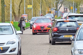 straat met veel auto's en fietsers