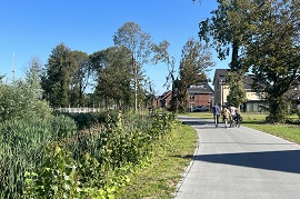 wandel- en fietspad in groene omgeving. Op het pad wandelen 4 mensen.