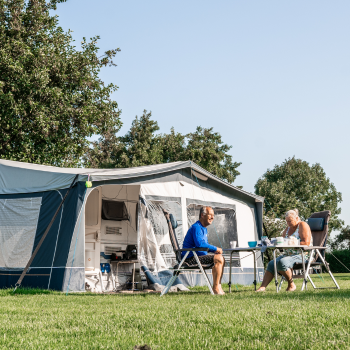 Een ouder stel voor hun tent op een camping in Delft