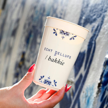 Een Echt Dellufs Bakkie in de hand voor een Delfts Blauwe muur
