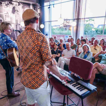 Publiek luistert naar muzikaal duo tijdens een optreden van het Delft Fringe Festival
