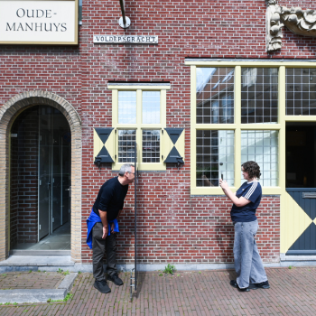 Twee mensen die een foto maken aan de voorzijde van het Vermeer Centrum Delft