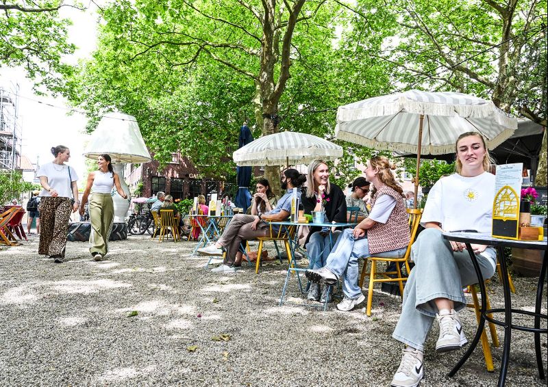 Twee meiden proosten op een zonnig terras