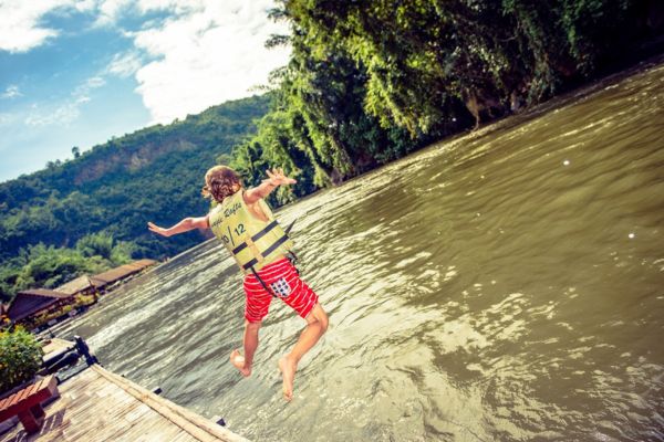 Jongetje springt in een rivier in Thailand