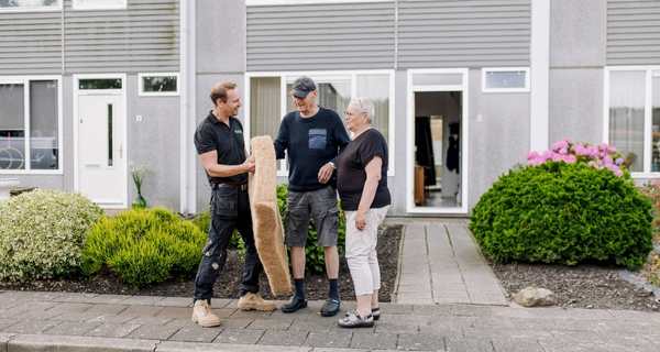 medewerker isolatiebedrijf legt isolatiemateriaal uit aan woningeigenaren
