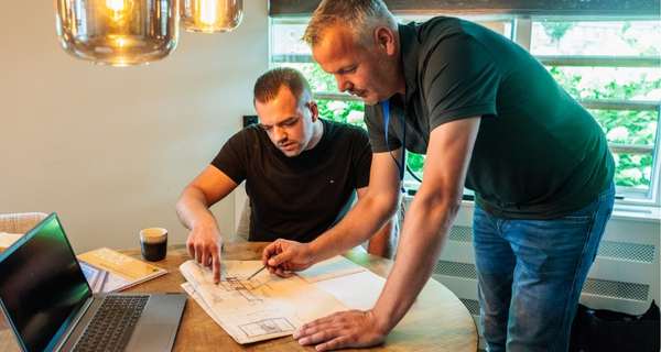 isolatieadviseur helpt woningeigenaar bij het maken van een isolatieplan aan de eettafel