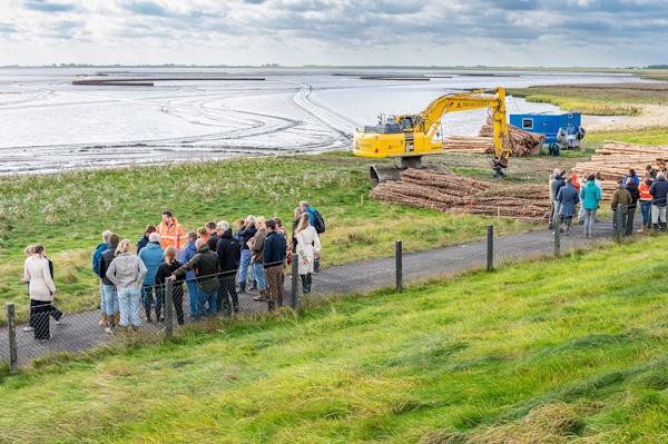 Boeren inspecteren een klomp klei op de proefakker