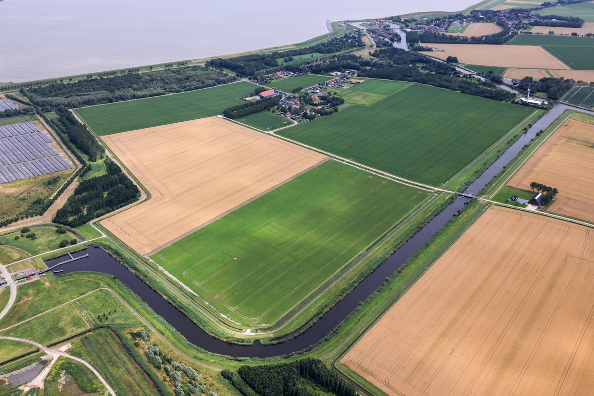 Boeren inspecteren een klomp klei op de proefakker