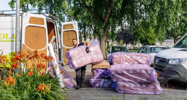 Medewerker isolatiebedrijf tilt isolatiemateriaal naar binnen