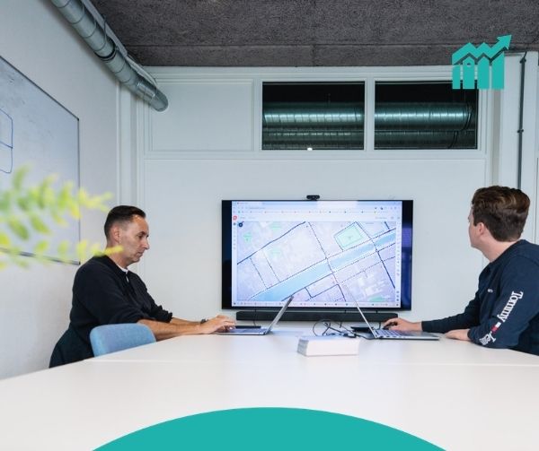 2 personen aan een tafel voor een scherm