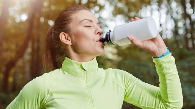 Vrouw drinkt uit bidon