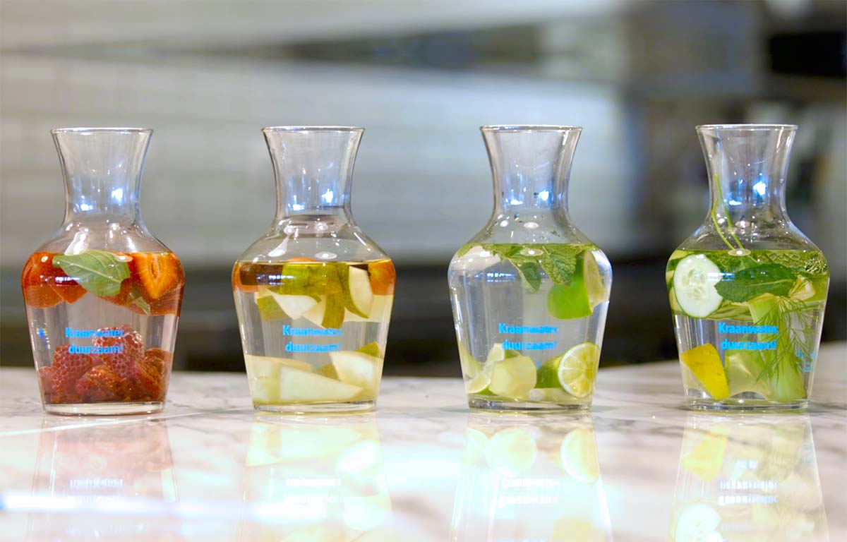 4 karaffen met kraanwater en fruit