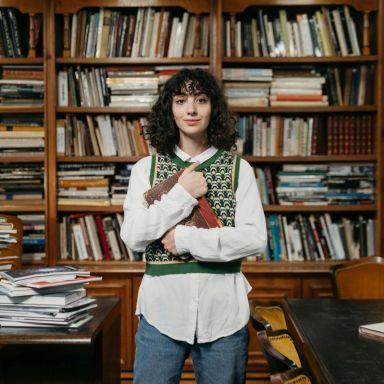 Student houdt een boek vast in de bibliotheek