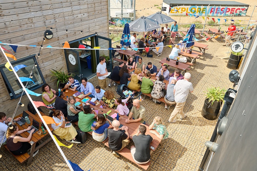 photo taken from above of people sitting on picnic benches