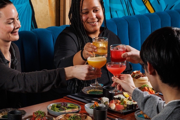 Friends enjoying cocktails and sushi